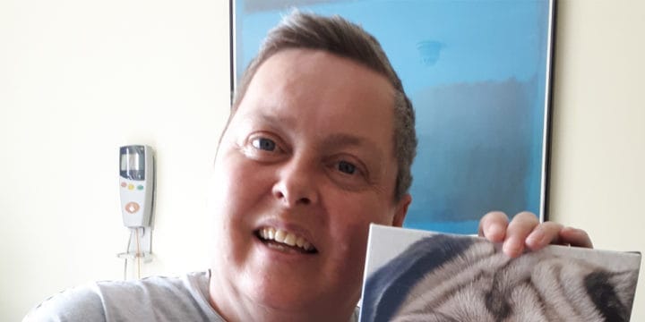 Sarah holding a photo of her pet