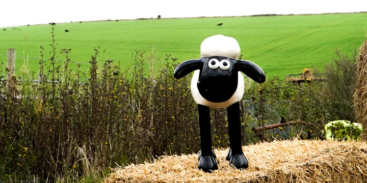 Shaun the Sheep standing on hay in a farm