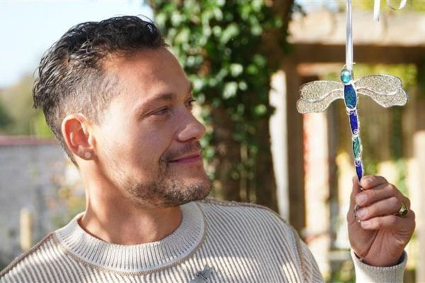 David looking at aglass dragonfly charm hanging form a tree at Martlets