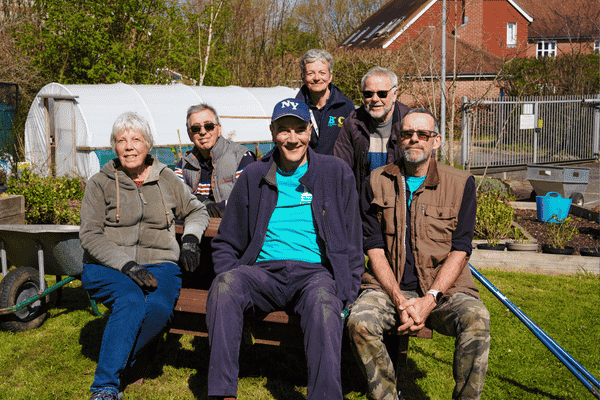 Group of six gardening volunteers - four men, two women, including Alison who has grey hair. All wearing gardeng gear.