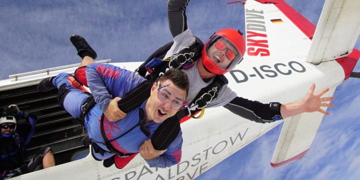 two people jumping out of a plane in tandem