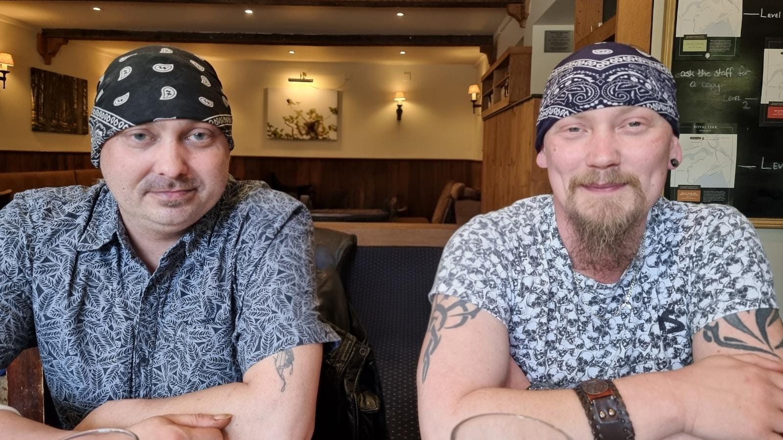 Dan and Carl sitting in a pub smiling at the camera