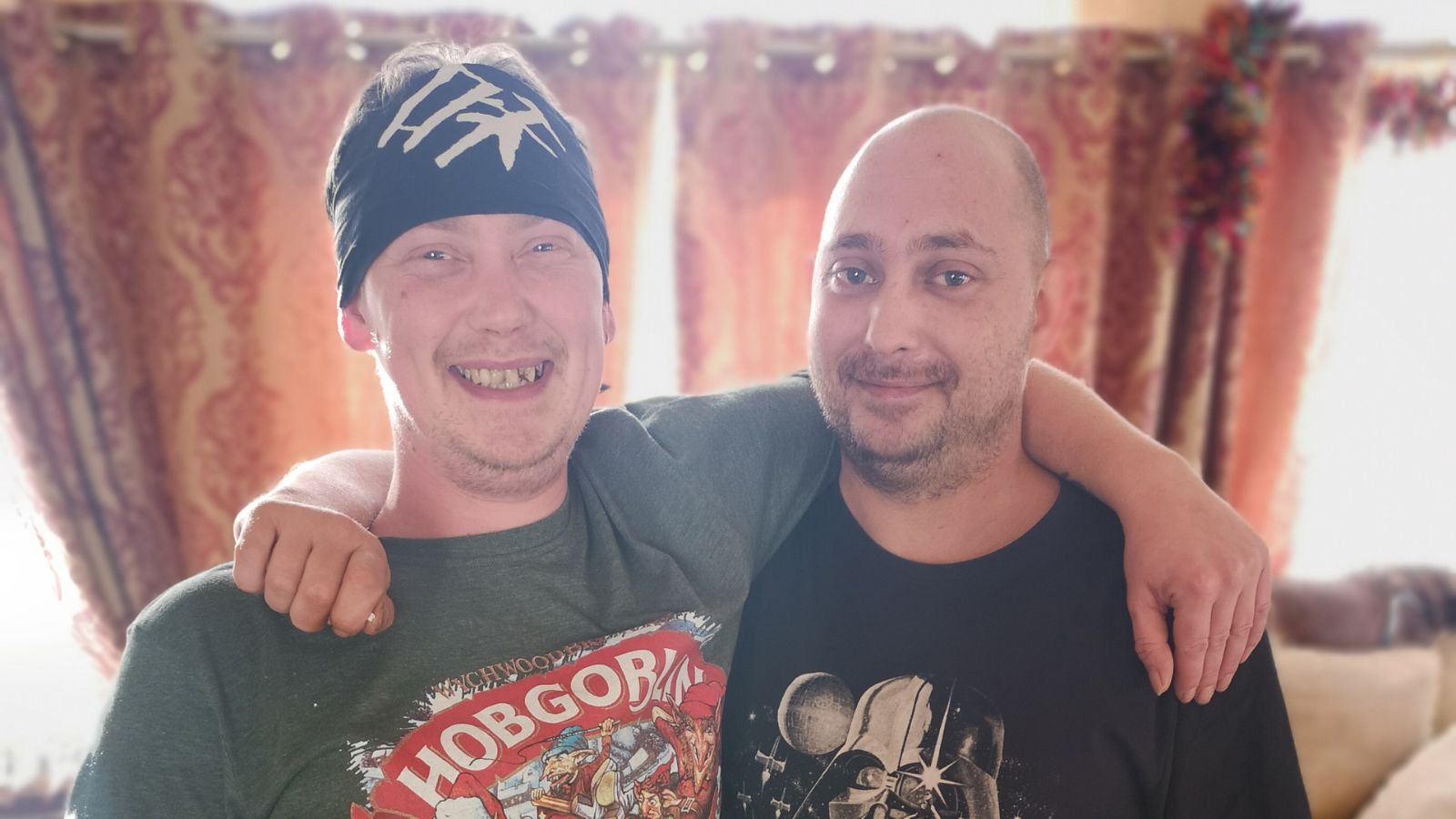 Dan and Carl with their arms around each other on Christmas and smiling at the camera