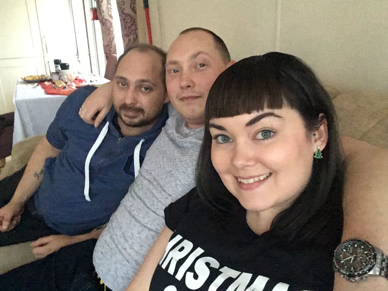 marie, dan and carl sitting on the sofa and smiling at the camera